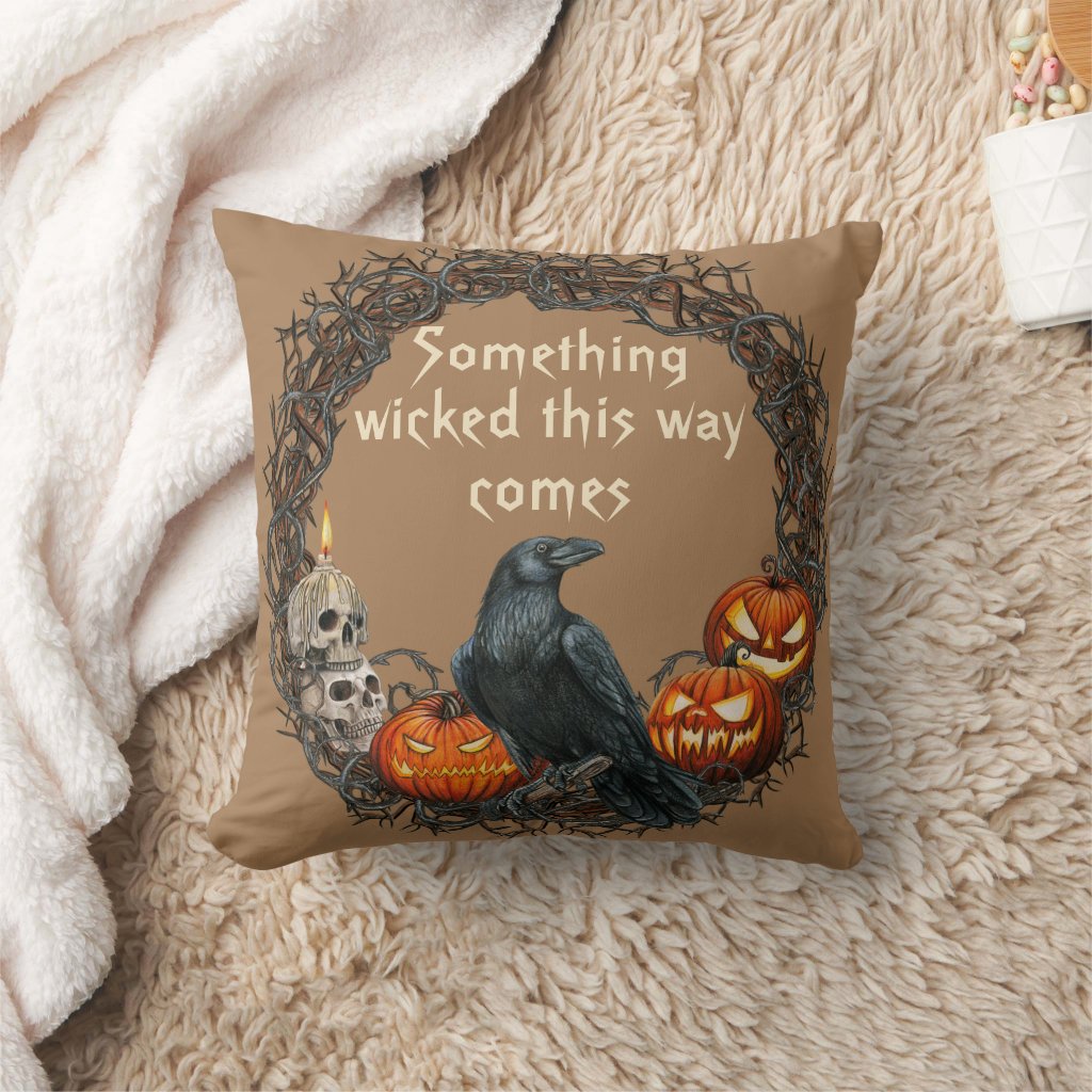 Halloween themed throw pillow features wreath with raven, skulls and sinister faced pumpkins on brown background and 