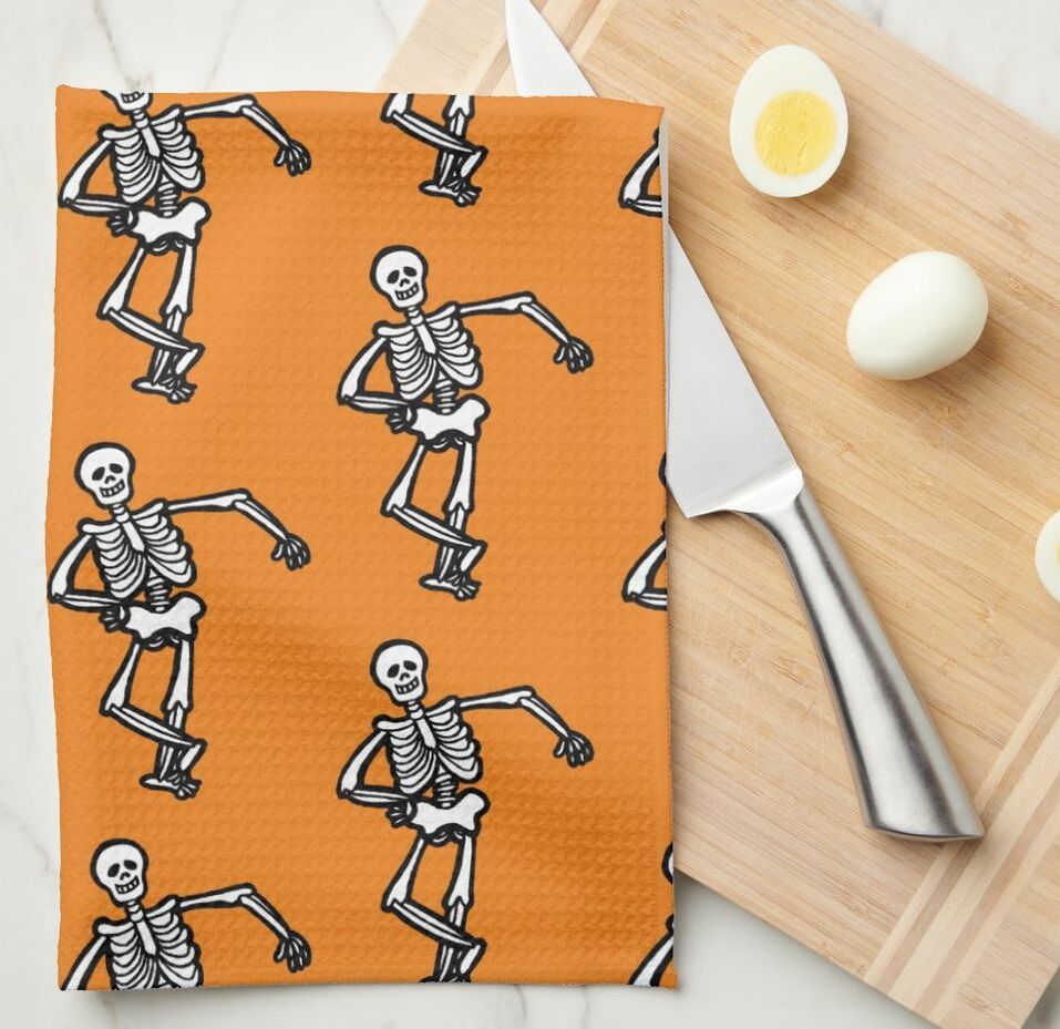 Orange kitchen towels with white dancing skeletons pattern